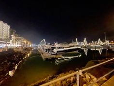 boats are docked in the harbor at night