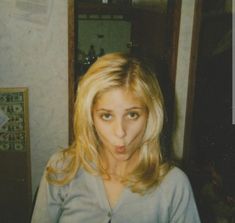 a woman making a funny face in front of a mirror