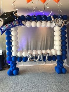 an arch made out of balloons with graduation decorations