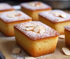 several pieces of cake with almonds and powdered sugar on top