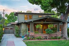 a house that is in the middle of a yard with trees and bushes around it