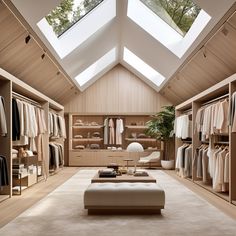 a large walk in closet with lots of clothes on hangers and an ottoman underneath the skylight