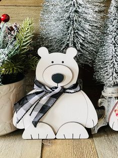 a white bear sitting next to some christmas trees