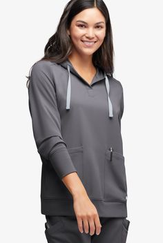 Who doesn’t love a hoodie? So comfortable – and it keeps chills off your head and neck. Here, rib-knit cuffs and bottom add extra softness. Every style in our Resurge collection is thoughtfully designed and responsibly sourced. Made of 100% recycled polyester (the most of any scrubs brand!), plus recycled trims and zippers. Even the bag it comes in is recycled. Long story short: Resurge lets you feel good and do good • Recycled fiber from approximately 21 plastic bottles • Modern fit • Hoodie st Stretch Hooded Tops With Pockets, Hoodie With Kangaroo Pocket, Functional Gray Hoodie With Pockets, Functional Gray Hoodie With Kangaroo Pocket, Stretch Hooded Activewear With Kangaroo Pocket, Stretch Activewear With Hood And Kangaroo Pocket, Stretch Activewear With Kangaroo Pocket And Hood, Gray Long Sleeve Activewear With Pockets, Sports Fleece Top With Pockets