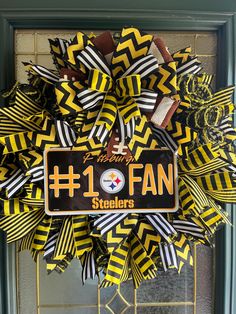 the football fan wreath is decorated with black, yellow and white strips on it's front door