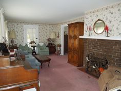 a living room filled with furniture and a fire place in front of a brick fireplace