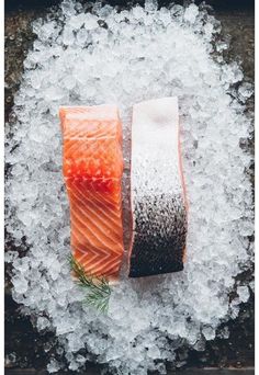 two pieces of salmon sitting on top of ice