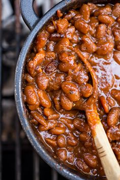 a wooden spoon in a pot filled with beans