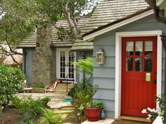 a red door sits in front of a blue house