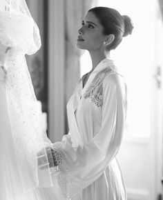 a woman standing next to a wedding dress