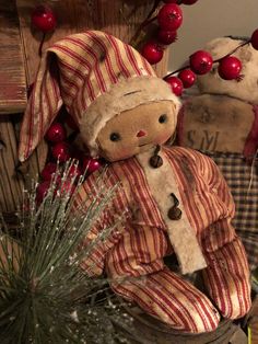 a teddy bear sitting on top of a wooden crate next to a christmas tree with berries