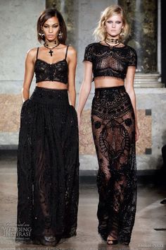 two models in black outfits on the runway