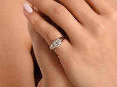 a woman's hand with a diamond ring on it