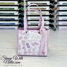 a pink and white bag sitting on top of a table next to stacks of folders