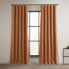 an orange curtain hanging in front of a window with a black metal rod on it