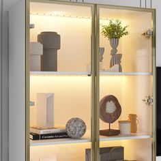 a glass display case filled with vases and other decorative items on top of white shelves