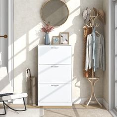 a white dresser sitting next to a window with a mirror on it's side