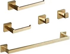 four brass bathroom accessories including towel bars, and toilet paper dispenser on a white background