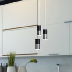 three lights hanging from the ceiling in a kitchen