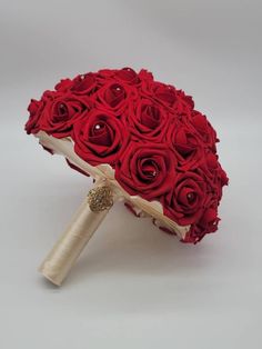 a bouquet of red roses sitting on top of a white table