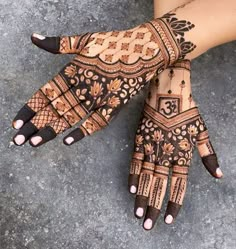 a woman's hand with henna tattoos on it