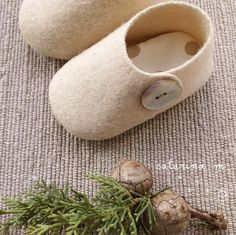 a pair of slippers sitting on top of a rug next to a pine cone