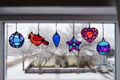 a window with stained glass ornaments hanging from it