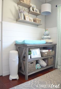 a baby's room with shelves and baskets on the wall, including a changing table