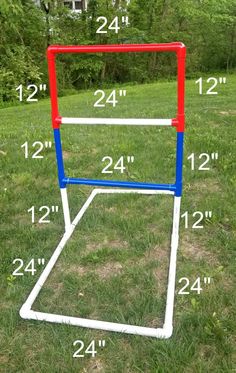 a red, white and blue soccer goal sitting in the middle of a field with measurements for it