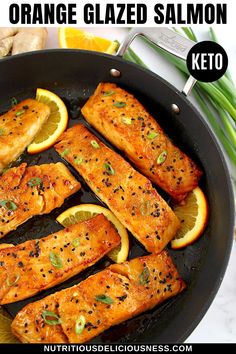 orange glazed salmon in a skillet with lemon slices