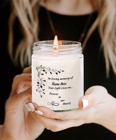 a woman holding a candle in her hands with a quote on the front and inside