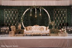 a couch sitting on top of a table next to a wall covered in greenery