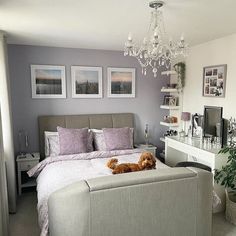 a bedroom with a large bed and chandelier hanging from it's ceiling