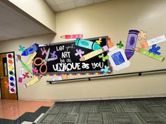 a bulletin board with school supplies on it in an empty room next to a door