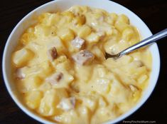 a white bowl filled with macaroni and cheese on top of a wooden table