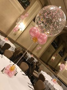 balloons and streamers fill the air over tables at a wedding reception in a ballroom