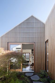 the house is made up of wooden slats and has a small garden in front