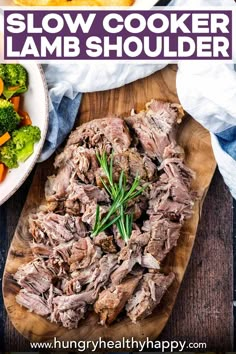 slow cooker lamb shoulder on a cutting board with broccoli and carrots