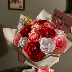 a bouquet of red, white and pink roses with a thank you note on it