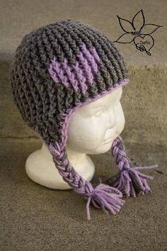 a white mannequin head wearing a gray and purple knitted hat with tassels