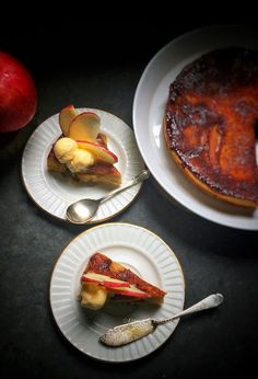 three plates with desserts on them sitting next to an apple