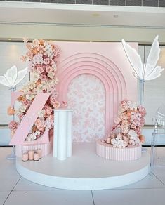 a pink and white stage set with flowers on it