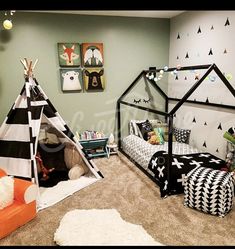 a teepee tent bed in the middle of a room with black and white decor