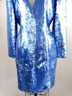 "This is an EXQUISITE hand sewn sequin dress and jacket! This ensemble is fully embellished with iridescent bright blue sequins. It's in perfect condition! Jacket Bust - 38/40\" Jacket Waist - 30\" Jacket Length - 29\" Skirt Waist - 28\" Skirt Hips - 40\" Skirt Length - 20\" This dress comes from a pet-free and smoke-free home. If you would like more info or have any questions, please don't hesitate to ask!" Blue Sequin Fabric With Contrast Sequin For Spring, Sequin Suit Women, Blue Sequin Fabric For Formal Occasions, Elegant Blue Sequin Fabric For Formal Occasions, Glamorous Blue Sequined Skirt, Vintage Sequined Formal Outerwear, Fitted Blue Sequin Fabric With Contrast, Luxury Blue Sequined Outerwear, Sequin Suit