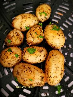 potatoes with herbs and seasoning in a grill grates on a black surface, top view