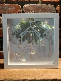 a paper cut nativity scene with the birth of jesus and baby jesus in white