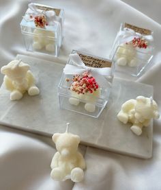 four small clear boxes filled with white and red candies