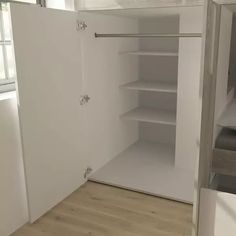 an empty closet with white walls and wooden floors