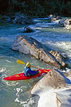 a person in a kayak paddling down a river