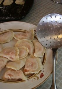 some dumplings are on a plate with a spoon and spatula next to them